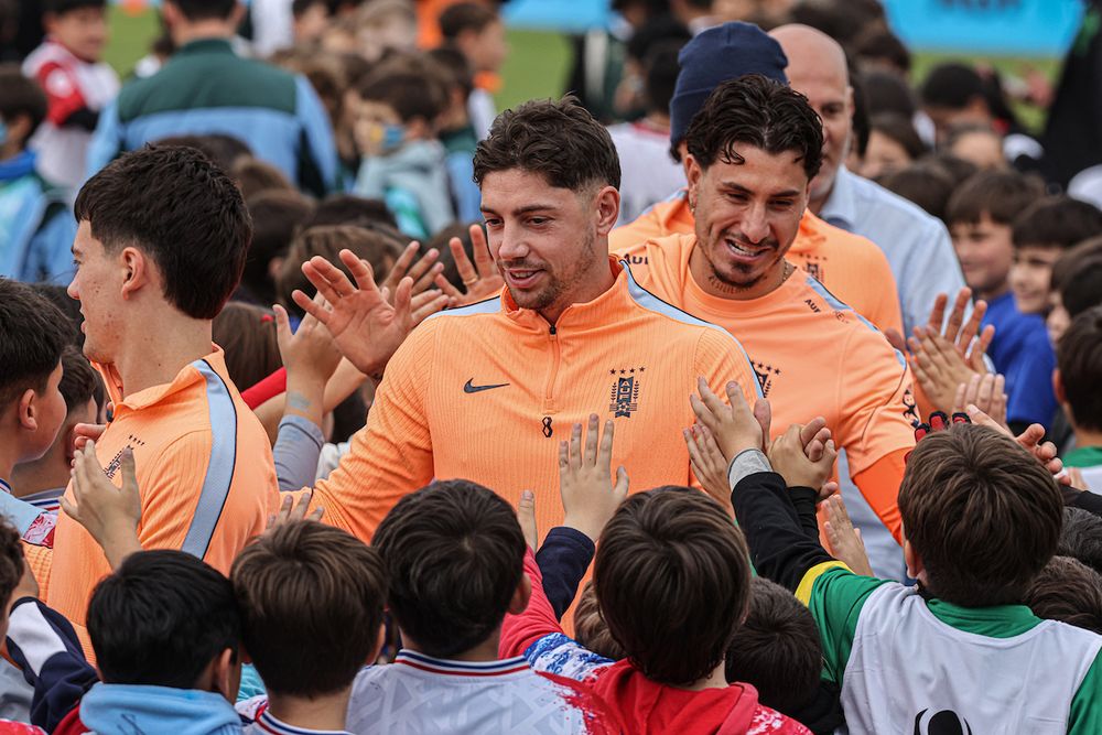 Federico Valverde y José María Giménez saludan a los niños en la despedida de la selección uruguaya en Pando