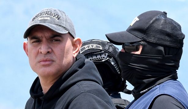 El presunto narcotraficante hondureño Mario José Calix, alias El Cubeta, es escoltado por miembros de la Dirección Nacional de Fuerzas Especiales (Cobras) durante su extradición a Estados Unidos en la base de Palmerola en Comayagua, a 50 km al norte de Tegucigalpa, el 4 de septiembre de 2024.