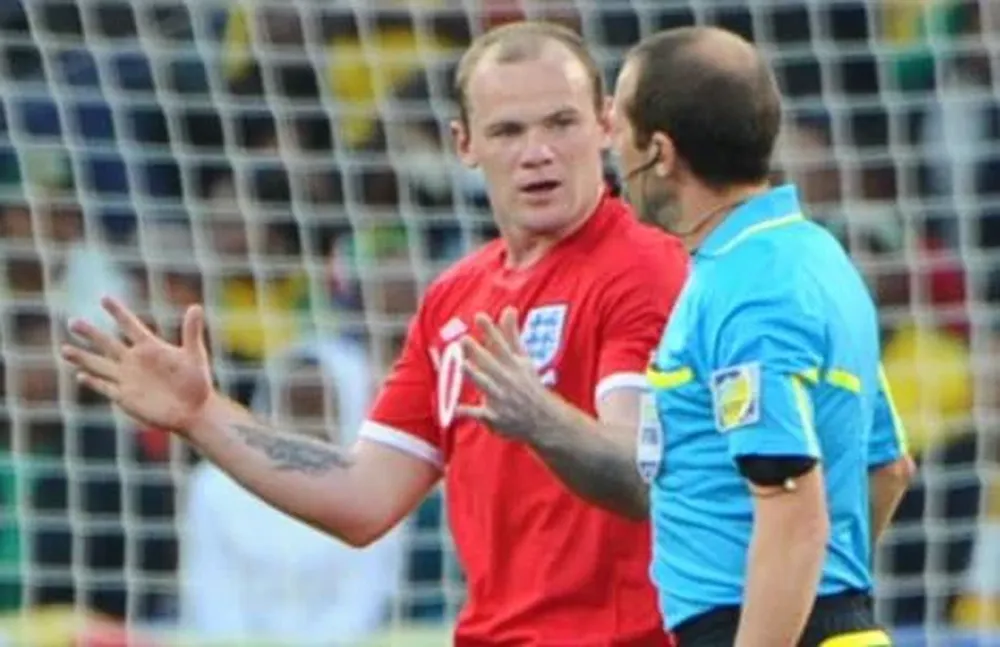 Rooney parece indicarle a Espinoza la distancia que entró el balón al arco
