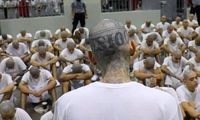 Un pandillero de la 18 da una oración de agradecimiento por la cena de Navidad que están a punto de degustar