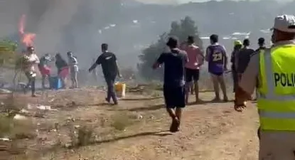 Captura de pantalla del video donde se ven algunas llamas del incendio en Pueblo Obrero y vecinos luchando para extinguirlas