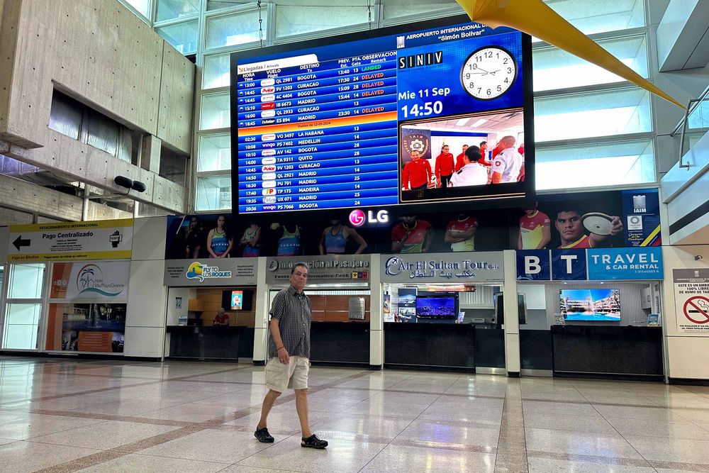 Un hombre camina frente a una pantalla con información de vuelos internacionales en el Aeropuerto Internacional de Maiquetía Simón Bolívar, este miércoles, en La Guaira (Venezuela).&nbsp;