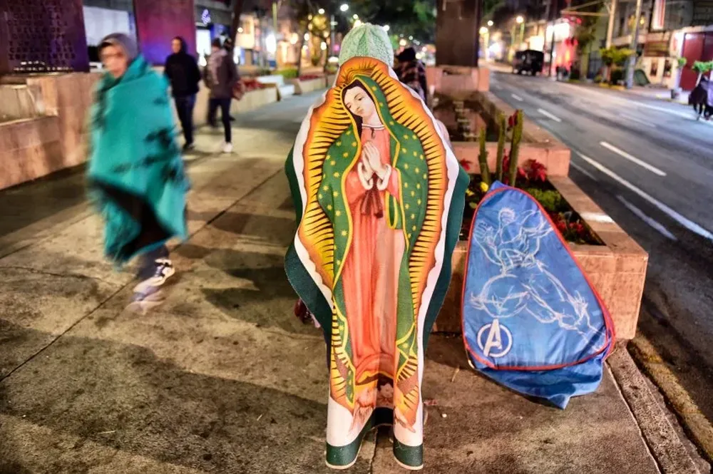 Peregrino envuelto en una imagen de la Virgen de Guadalupe en Ciudad de México.