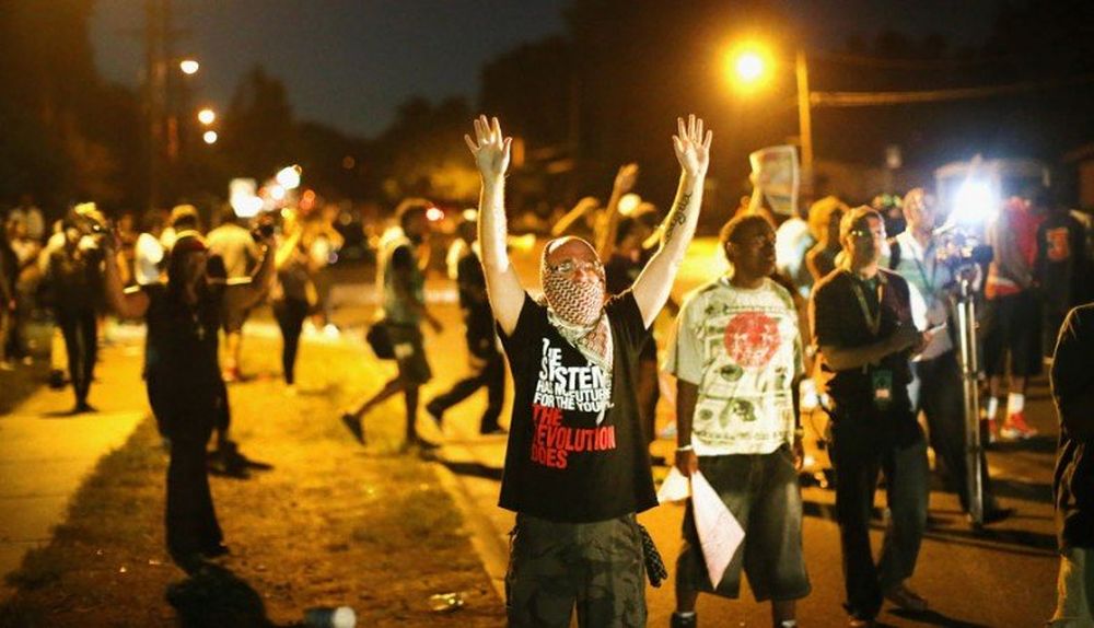En las protestas la gente alza los brazos, como se supone que hizo Brown antes de morir.