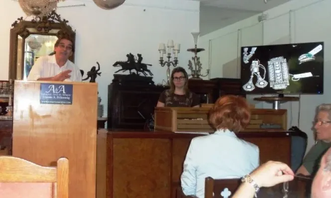 El rematador Ernesto Prilassnig subastando alhajas en la subasta de joyas, relojes y monedas