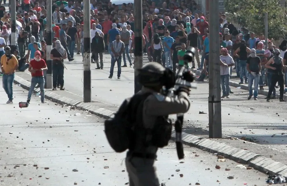 Un agente israelí reprime una manifestación de palestinos.