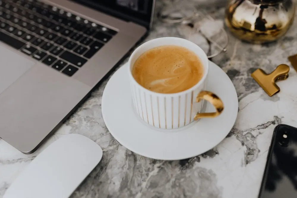 foodiesfeed.com_coffee-in-a-white-cup-on-a-marble-desk.webp