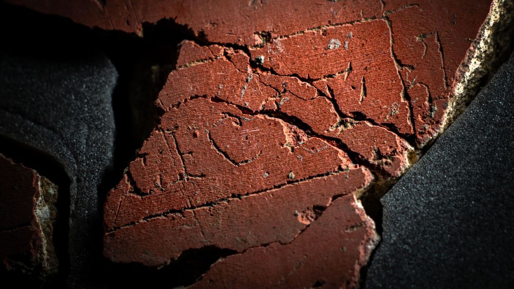 La palabra latina FECIT, que significa "ha hecho esto", se ve grabada en el yeso.