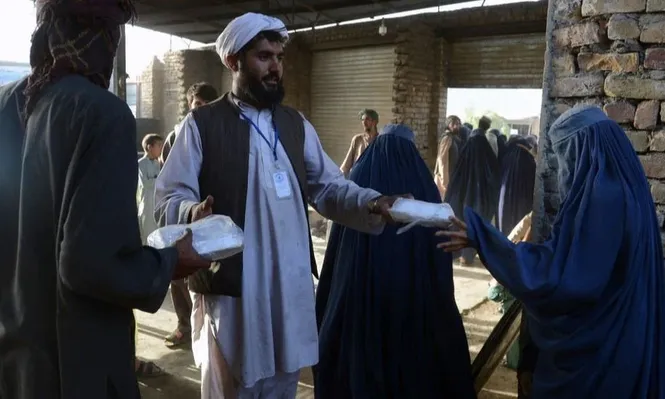 Mujeres en burkas recibiendo ayuda alimentaria en Kandahar el mes pasado.