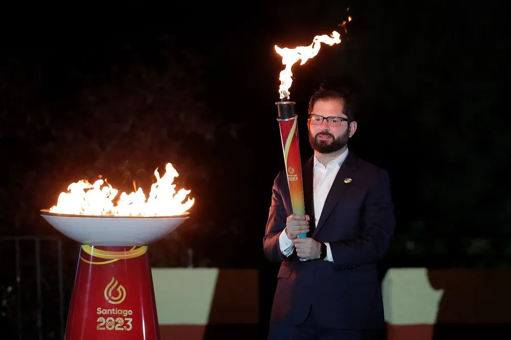 El presidente de Chile, Gabriel Boric, sostiene la antorcha de los Juegos Panamericanos 2023