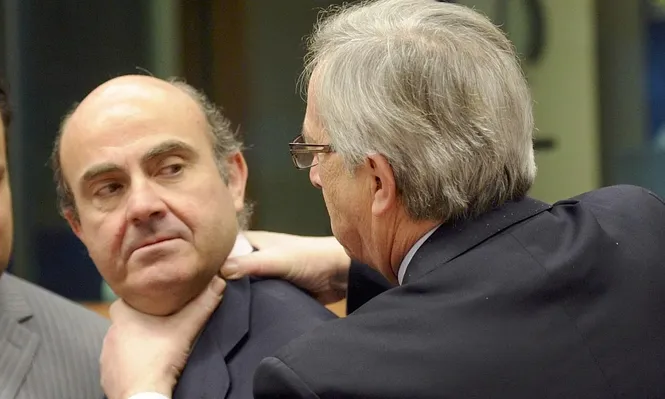 El primer ministro de Luxemburgo, Jean-Claude Juncker, bromea con el ministro de Economía español, Luis de Guindos, tomándolo del cuello