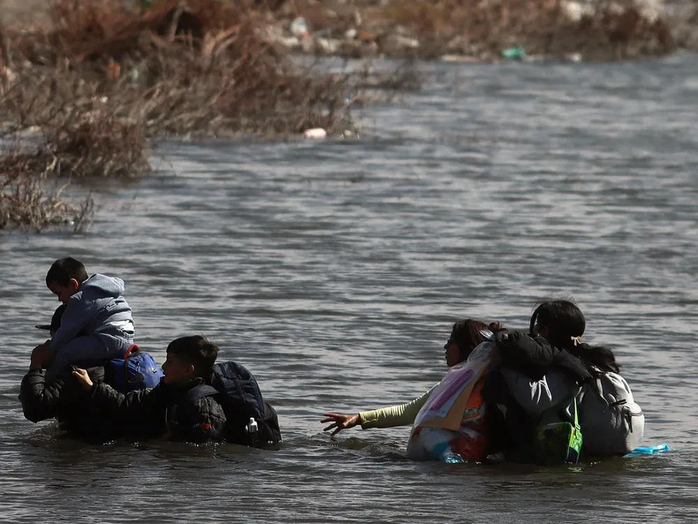 Latinos cruzan el Río Bravo en la frontera de Estados Unidos.