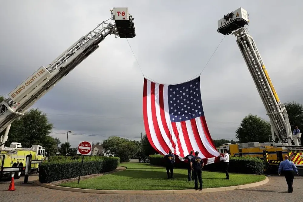 Bomberos de los condados de Henrico y de Chesterfield levantan una bandera de Estados Unidos