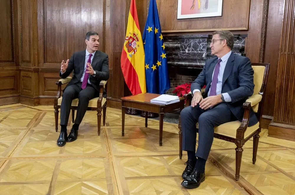 El presidente del Gobierno, Pedro Sánchez (i), y el líder del PP, Alberto Núñez Feijóo (d), conversan durante una reunión, en el Congreso de los Diputados.