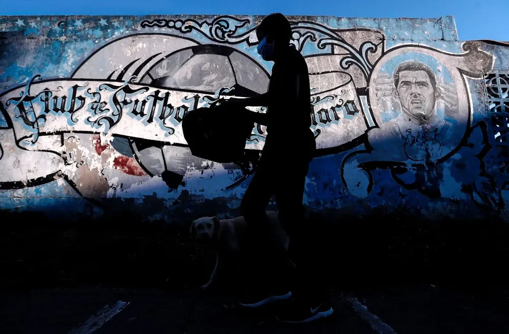 Un chico del barrio Fuerte Apache camina con una bolsa con comida