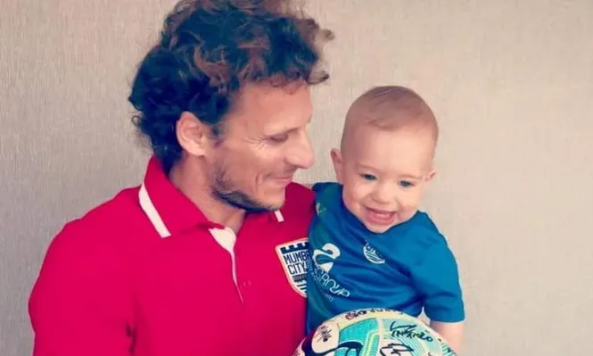 Diego Forlán con su hijo Martín y la pelota ganada por su hat trick