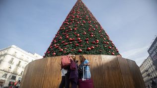 Turistas junto al árbol de Navidad de la Puerta del Sol