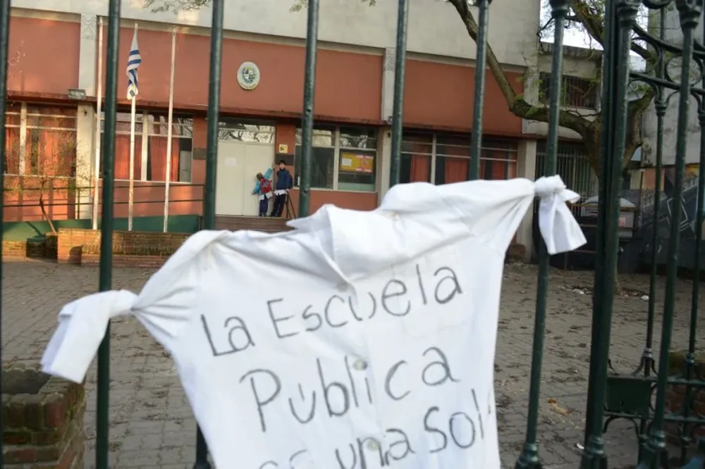 Alumnos de la escuela N°77 en la Aguada tocando el timbre para que abran la escuela en un día de paro