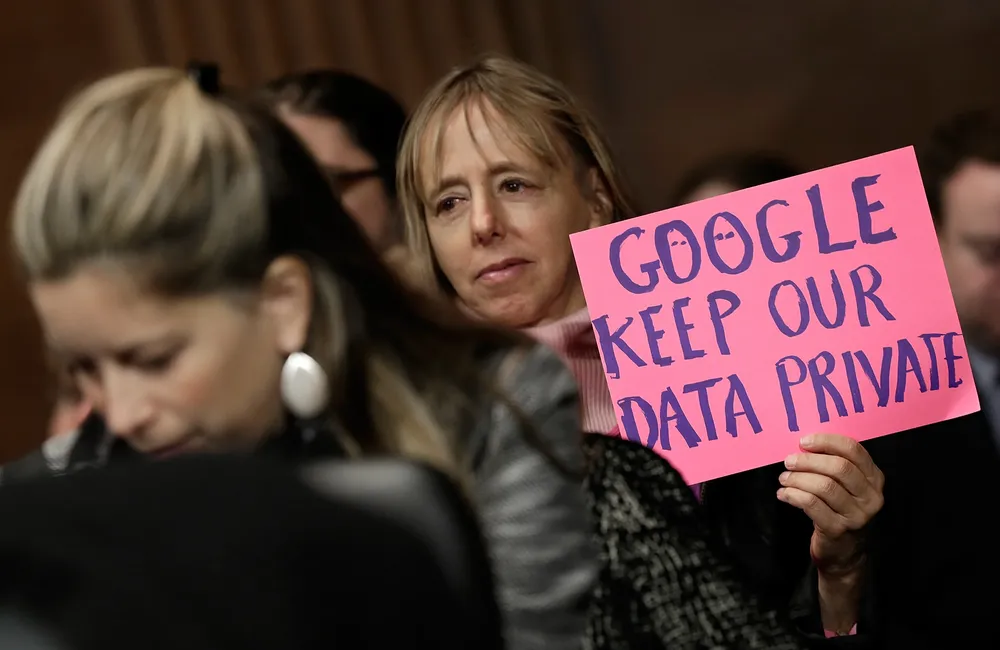 Google, mantén privada nuestra información, dice el cartel, durante el comité sobre transparencia de la vigilancia, el 13 de noviembre