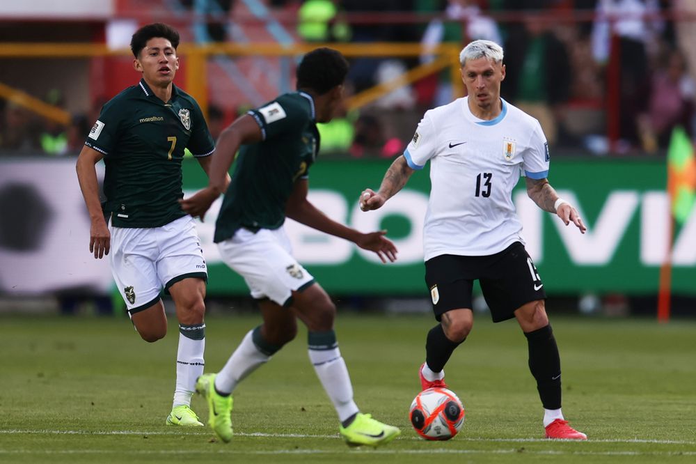 Diego Román de Bolivia disputa un balón con Guillermo Varela de Uruguay por Eliminatorias