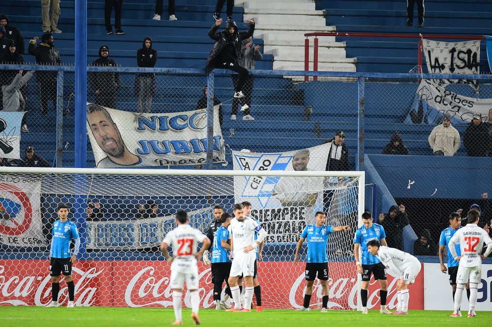 Hincha de Cerro trepados al alambrado de la tribuna Héctor Scarone