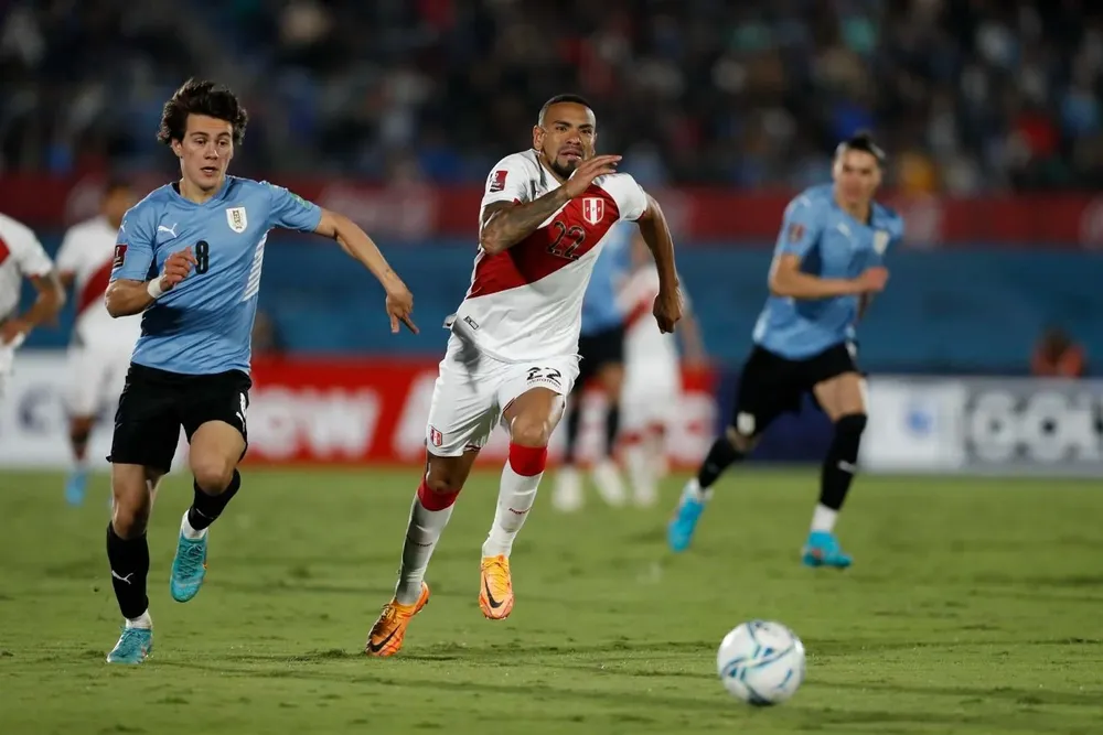 El peruano Alexander Callens corre junto a Facundo Pellistri