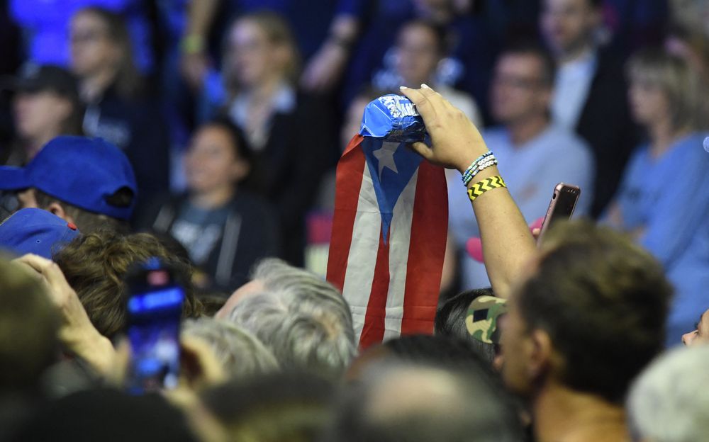 Un asistente flamea la bandera de Puerto Rico durante un acto demócrata en Filadelfia