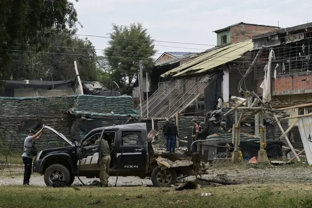 Investigadores revisan el auto bomba que las FARC disidentes hicieron estallar frente a un puesto policial este domingo. AFP