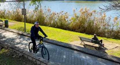 Una persona disfruta haciendo deporte junto a la orilla del río Guadalquivir a su paso por Sevilla, este sábado.