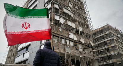 Un hombre sujeta una bandera iraní tras un ataque en Teherán, Irán, el 2 de marzo del 2026.&nbsp;