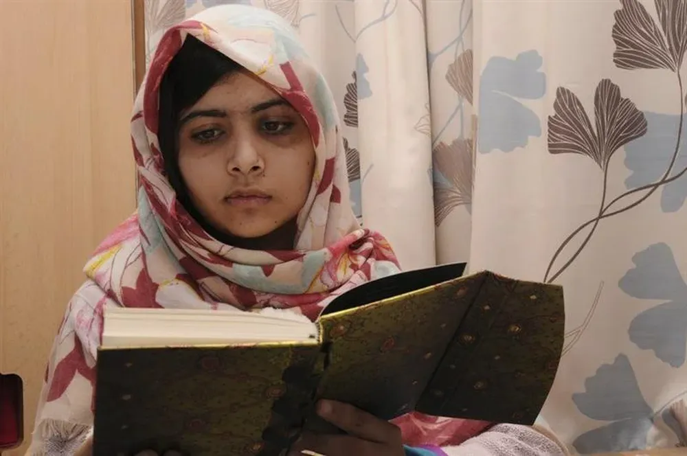 Imagen distribuida por el Hospital Universitario de Birmingham hoy que muestra a Malala leyendo