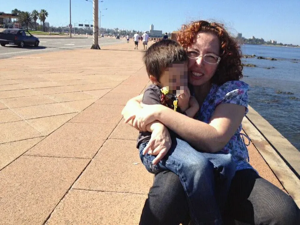 Alessandra Spiller y su hijo en la rambla de Montevideo.