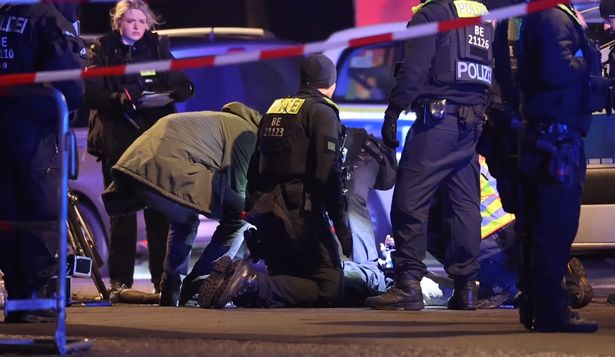 Agentes de policía asisten a un español apuñalado con un cuchillo junto al monumento a las víctimas del Holocausto este viernes, en Berlín (Alemania).