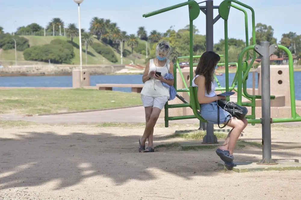 Jóvenes en las hamacas de la rambla de Montevideo