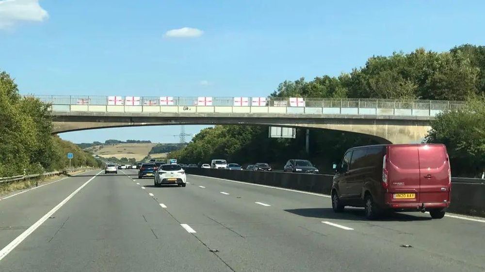 Banderas de la Cruz de San Jorge colocadas en un puente sobre una autopista en el oeste de Inglaterra