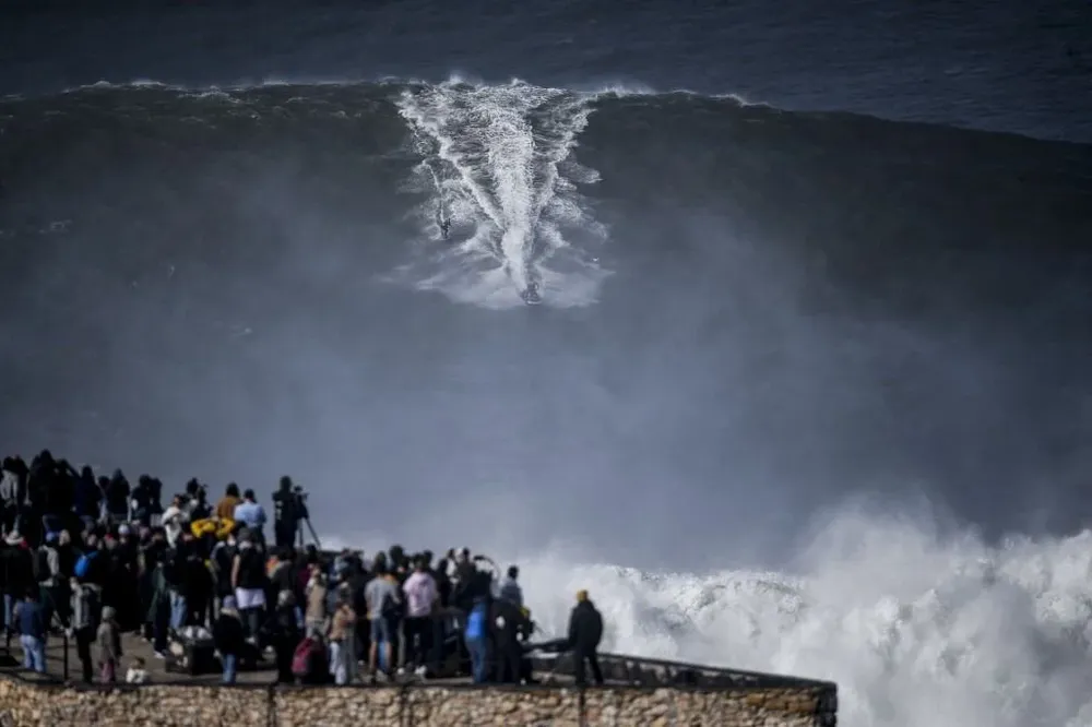 Espectadores mirando un surfista en Nazaré