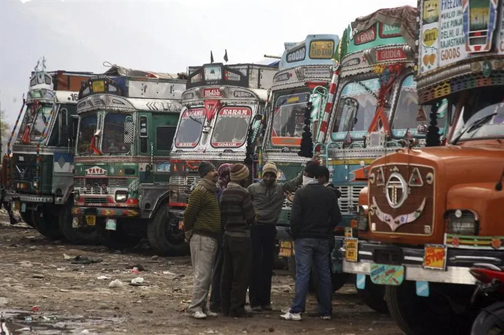 Comerciantes indios esperan junto a sus camiones a la reanudación del comercio en Chakan-da-Bagh
