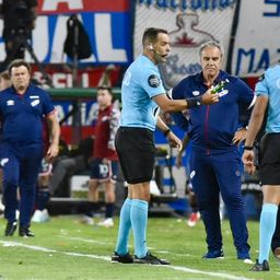 Esteban Ostojich entrega al encargado de seguridad una petaca que cayó desde la tribuna