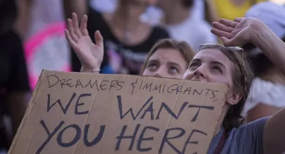 Una mujer sostiene un cartel que dice Soñadores e inmigrantes, los queremos acá, en una manifestación en Los Ángeles a fines de junio