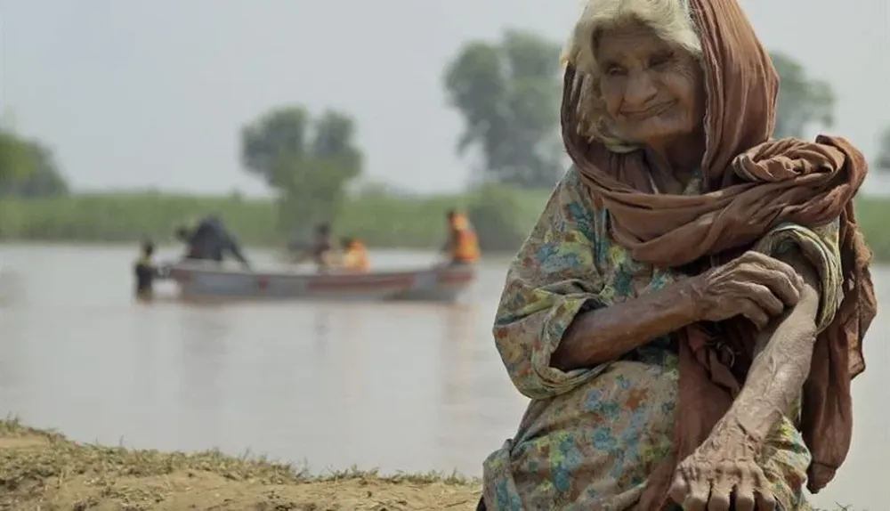 Pakistán. Una anciana espera a ser evacuada en una zona inundada en Chiniot