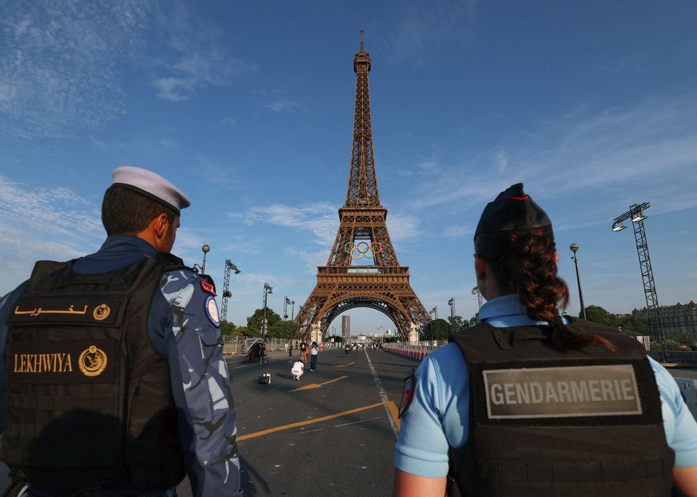 La Fuerza de Seguridad Internacional Lekhwiya Qatar hace guardia junto a un gendarme francés mientras patrullan frente a la Torre Eiffel decorada con los anillos olímpicos &nbsp; &nbsp;