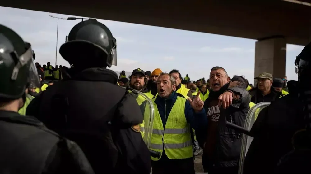 Decenas de agricultores cortan la carretera y se enfrentan a los antidisturbios en la autovía A-3, este jueves en Valencia