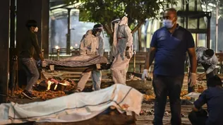 Los familiares y el personal médico llevan el cadáver de una víctima del covid-19 en el crematorio Nigambodh Ghat, a orillas del río Yamuna en Nueva Delhi.