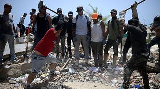Voluntarios golpean restos de concreto con mazos de hierro buscando sobrevivientes bajo los escombros.