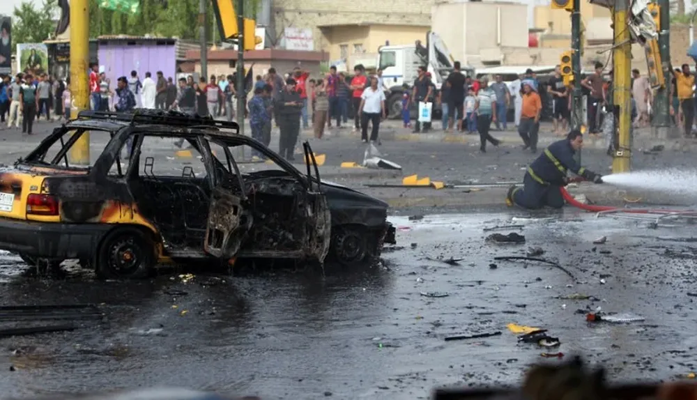 Miembros de los servicios de emergencia iraquíes extinguen el fuego en un coche bomba que estalló en Bagdad