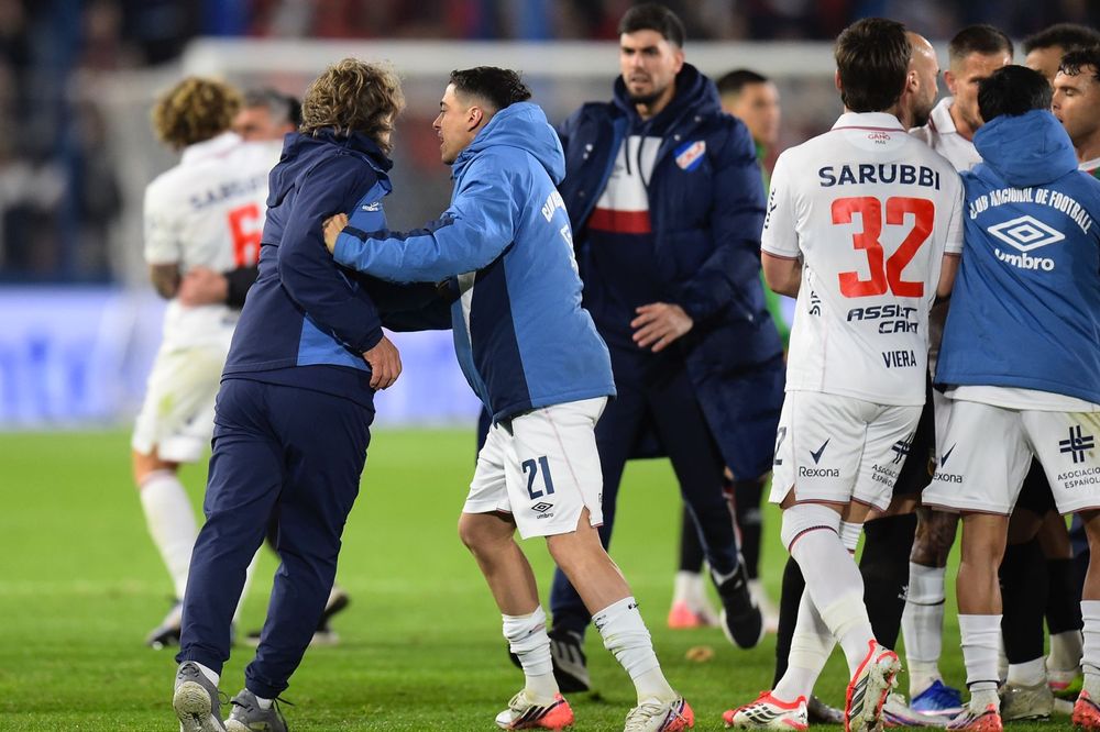 Camilo Cándido de Nacional trata de detener a Daniel Carreño en el final en el que hubo algunos insultos con jugadores de Deportivo Maldonado por el Torneo Clausura