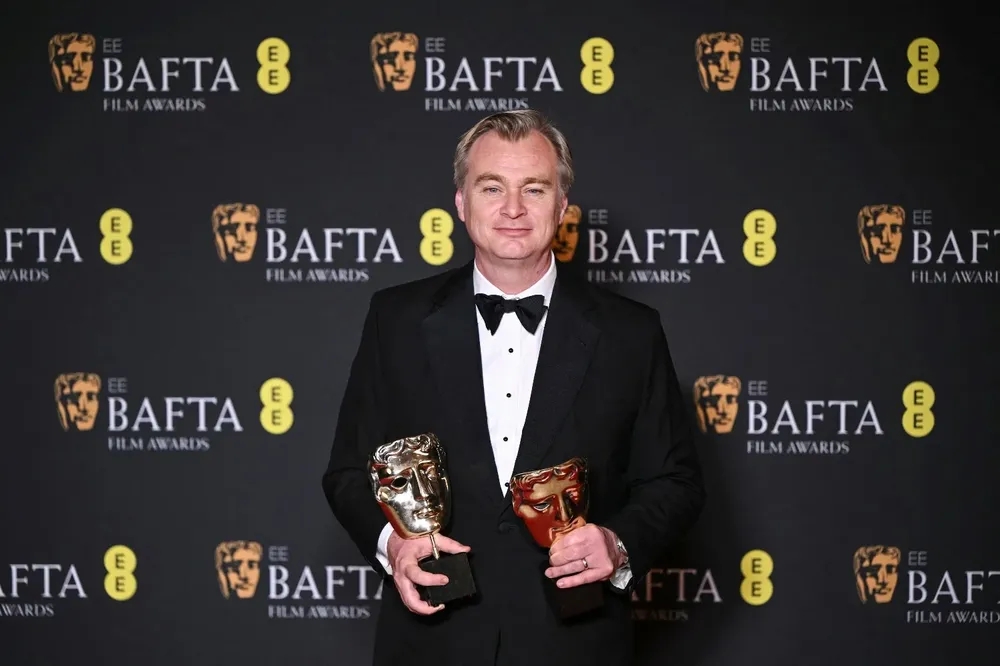 Christopher Nolan posa con los premios BAFTA por su film sobre el padre de la bomba atómica.