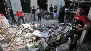 Ciudadanos iraquíes inspeccionan el lugar de la explosión