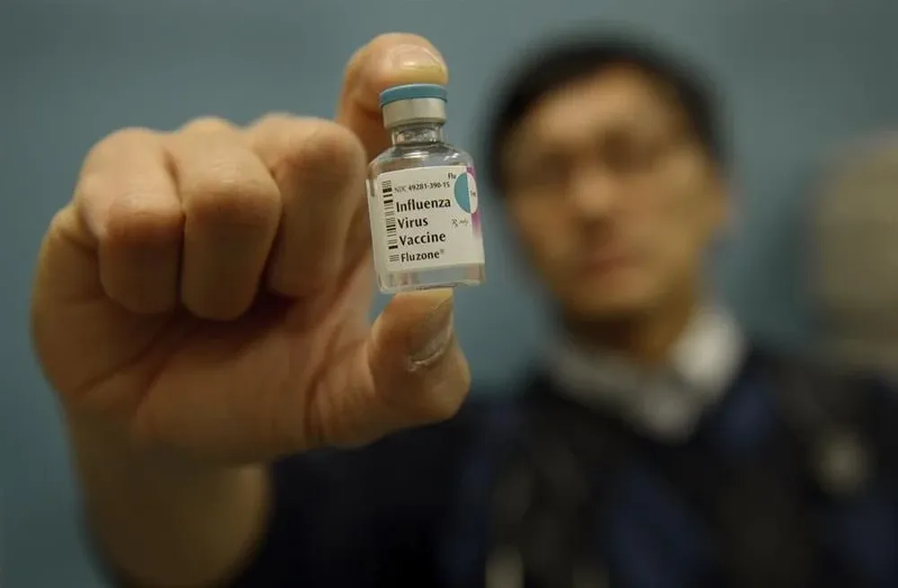 EUA- Un médico sostiene una dosis de vacuna de la gripe en un consultorio médico en Nueva York