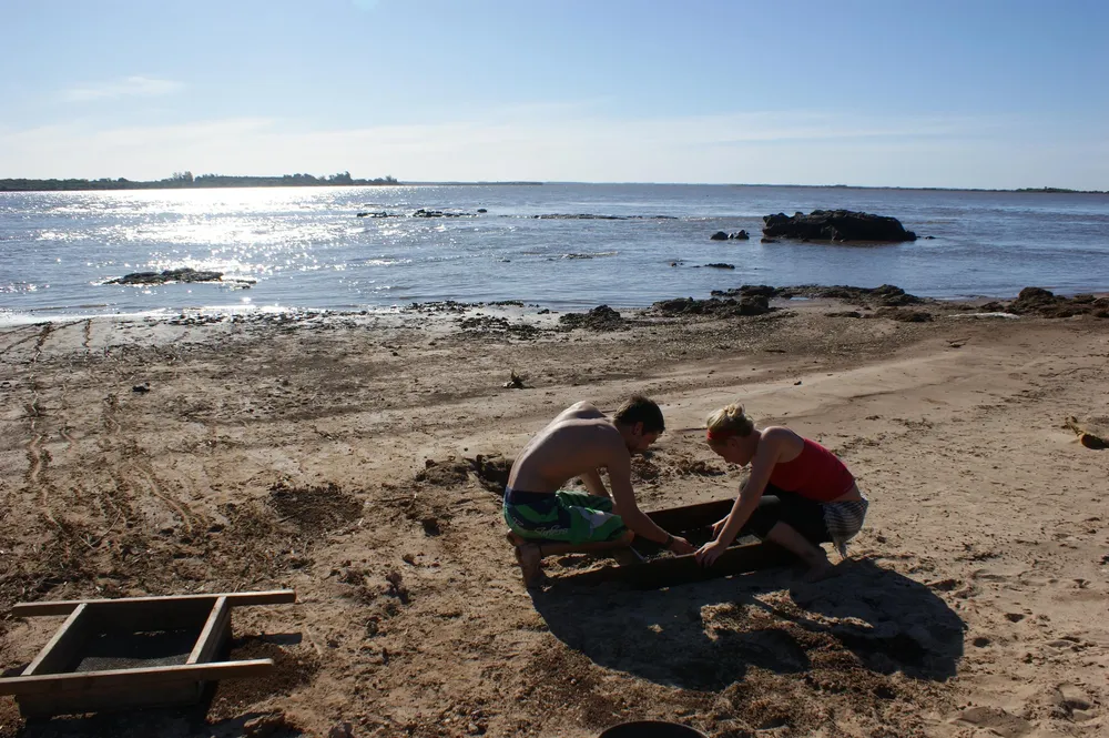 Investigadores zarandeando el sedimento del sitio arqueológico K-87 en el río Uruguay